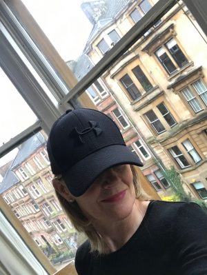 A woman wearing a skip cap which hides her eyes 